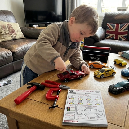 Child playing pretend mechanic with toy cars and and role play notepad 