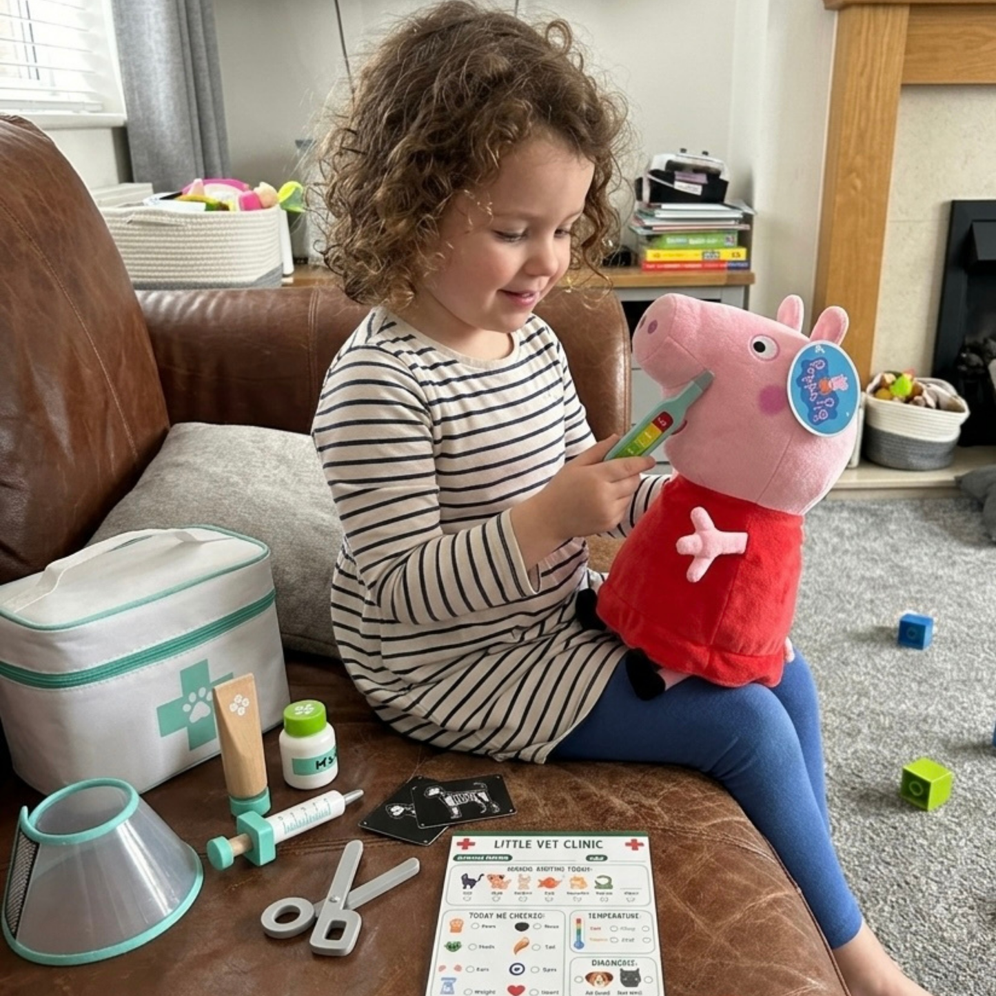 Child playing with a toy vet set on a couch